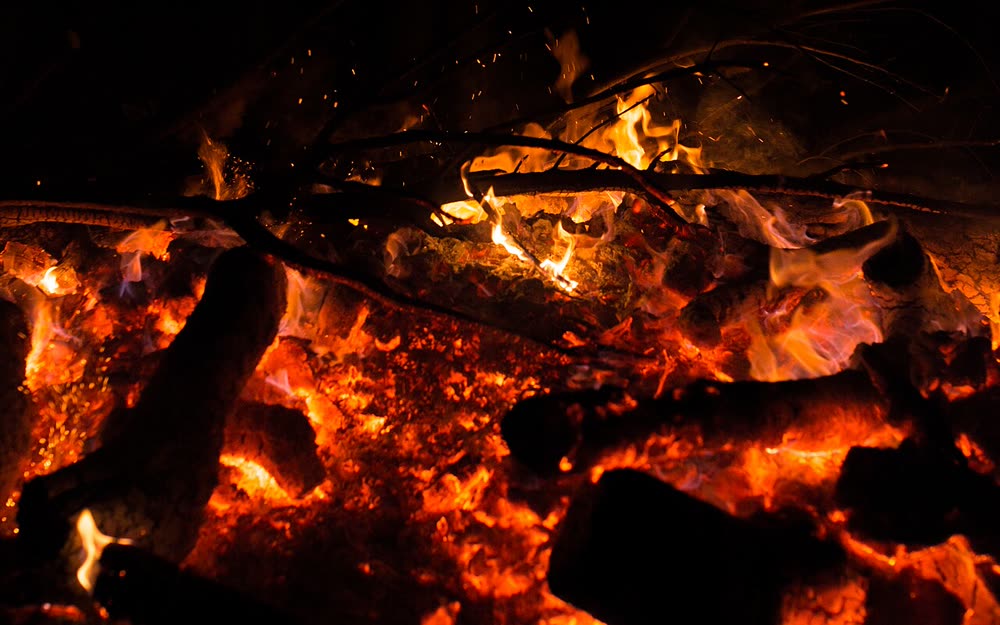 Embers and flames of a communal fire at night